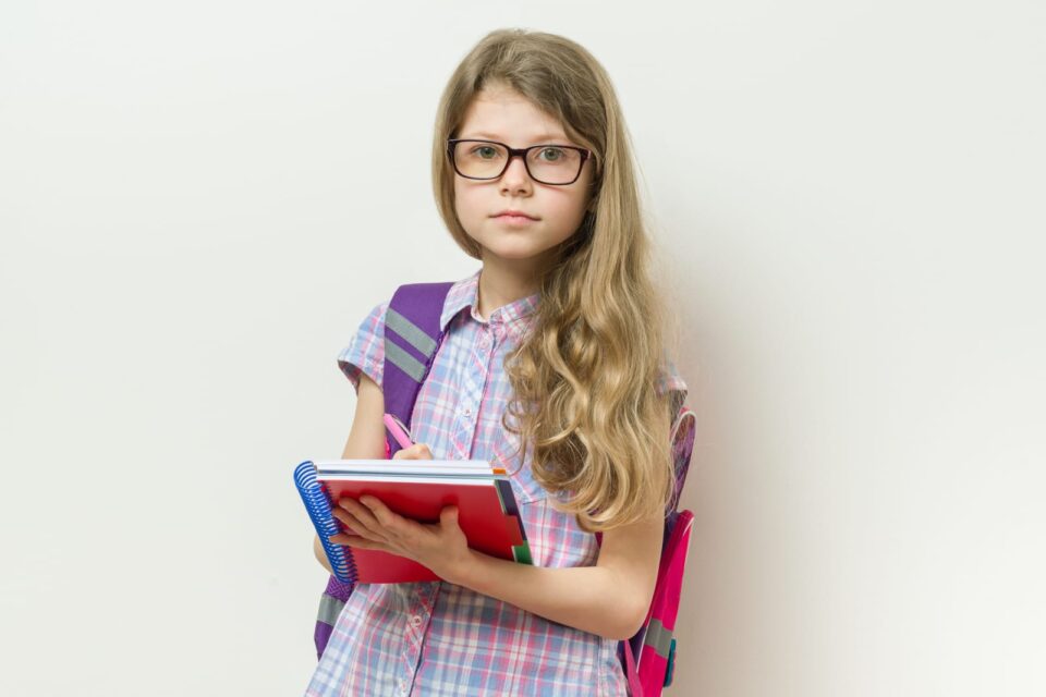 school age girl with glasses and notebook.